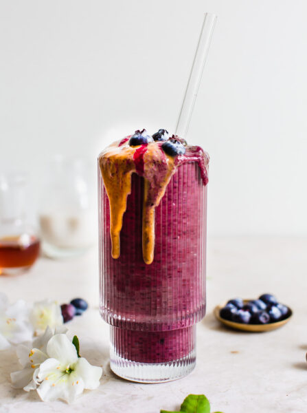 blueberry smoothie in a glass with nut butter